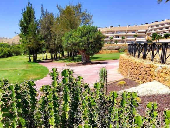 A scenic view of a golf course with frontline golf apartments in the background at Alenda Golf