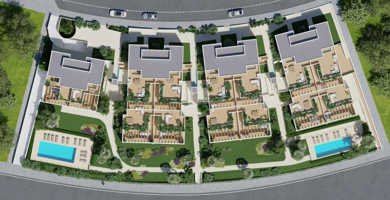 A panoramic view of Font del Llop Golf Course with modern duplex residences and a clear blue sky.