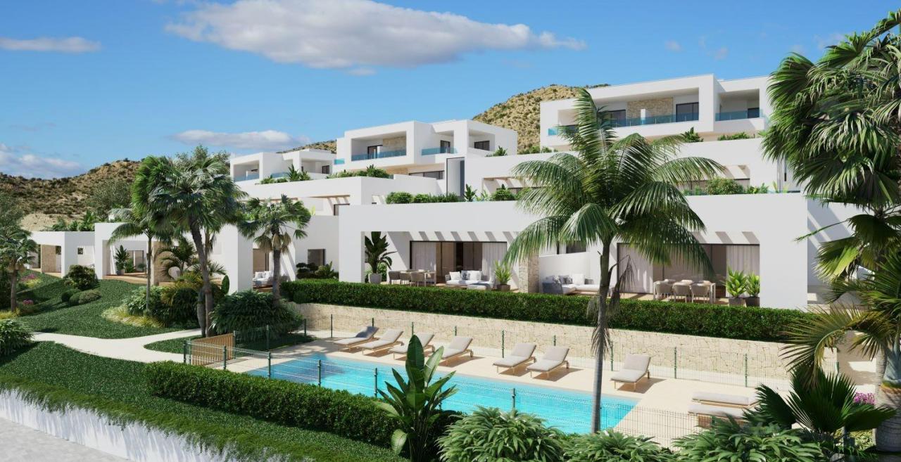 A panoramic view of Font del Llop Golf Course with modern duplex residences and a clear blue sky.