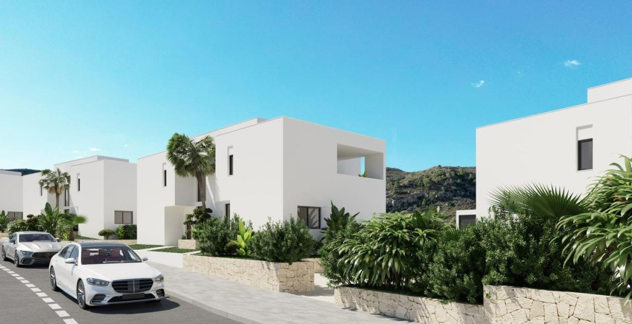 A panoramic view of Font del Llop Golf Course with modern duplex residences and a clear blue sky.