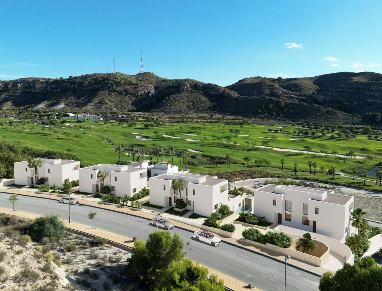 A panoramic view of Font del Llop Golf Course with modern duplex residences and a clear blue sky.