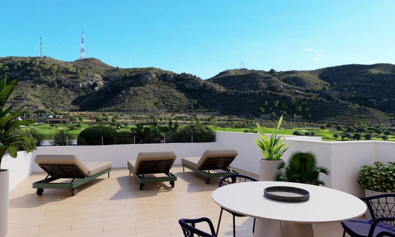 A panoramic view of Font del Llop Golf Course with modern duplex residences and a clear blue sky.