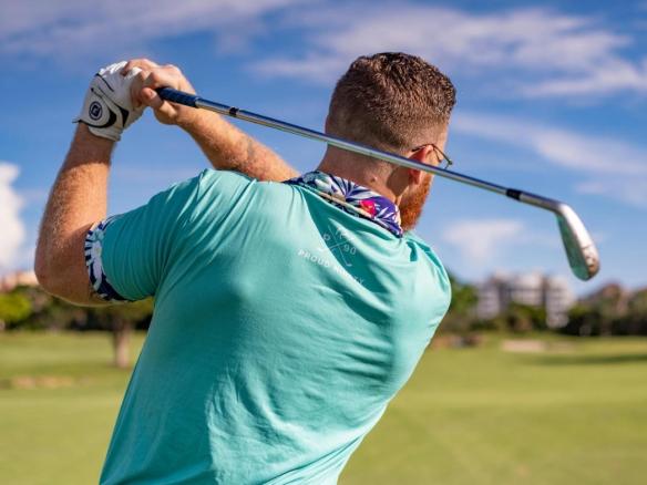 Sunny day, with a lush golf course and clear blue sky in the background.