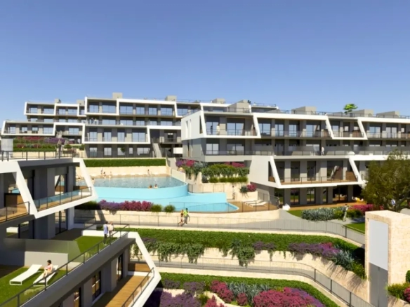 Modern apartment complex in Spain with terraces and a pool.